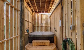 A wooden interior with a hot tub, wooden walls, and a bench. - The Blue Crab | 1 Block to Beach & Center Street | Seasonal Hot Tub | Outdoor Living | Sleeps 8 (Folly Beach)