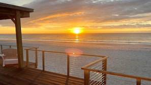 A wooden deck with a railing overlooking a beach at sunset. - Paradise Found - Updated Classic 3 BR Home - Direct Oceanfront! (North Topsail Beach)
