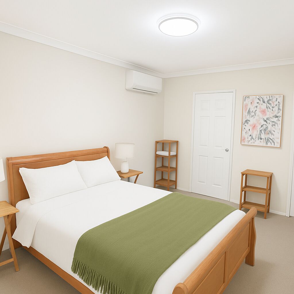 A neatly arranged bedroom with a wooden bed, a bedside table with a lamp, a small wooden shelf, and a door.