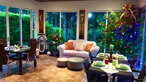 A dining area with a Christmas tree, a sofa, and a table set for a meal.