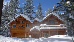 A large wooden lodge with multiple levels, surrounded by snow-covered trees. - Tahoe Ski Lodge  WiFi, hot-tub sleeps 12 (Truckee)