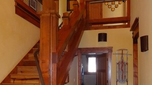 A wooden staircase with a metal handrail leading to a second floor. A door at the bottom leads to a hallway with a stone floor. - Tahoe Ski Lodge  WiFi, hot-tub sleeps 12 (Truckee)