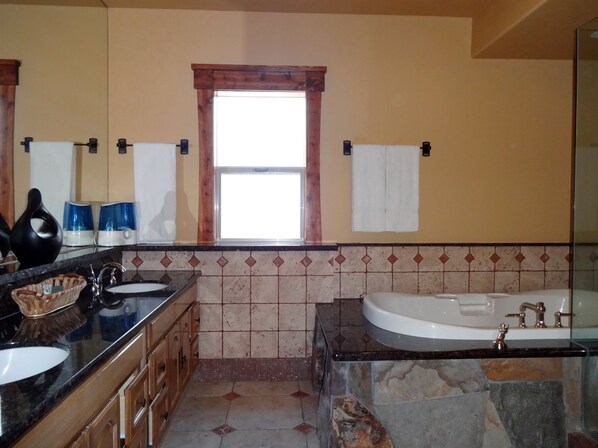 A bathroom with a large window, a bathtub, a sink, and a vanity with a mirror. - Tahoe Ski Lodge WiFi, hot-tub sleeps 12 (Truckee)
