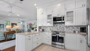 A modern kitchen with white cabinetry, a built-in microwave, and a stainless steel oven.
