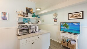 A kitchen with a built-in oven, coffee maker, and a TV on a stand. - #110 Picture Perfect Studio w Sleeper Sofa & Pool (Isle of Palms)