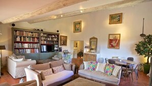 Een gezellige woonkamer met banken, een salontafel, een boekenkast en een eethoek.