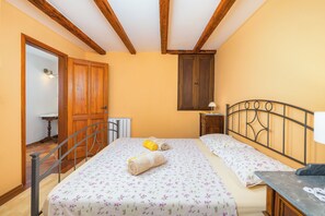 A bedroom with a bed, a wooden wardrobe, a nightstand, and a radiator.