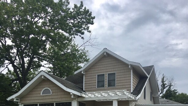 A two-story house with a covered porch, a garage, and a well-maintained front yard with white hydrangea bushes. - Adorable Beach Bungalow - Awesome location! Walk to beach and town! (South Haven)