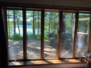 A large window with multiple panes, offering a view of a deck and outdoor furniture. - Family Fun...Lake Home,Kayaks,SUP.Pontoon Paddle Boat,Free WiF & Direct TV (Lewiston)