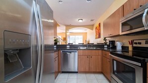 A modern kitchen with stainless steel appliances, wooden cabinets, and a dishwasher.