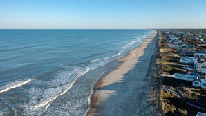 A coastal view with a beach and houses along the shore. - 718 Dog-Friendly, Ocean-Side Duck w/ Private Pool (Duck)