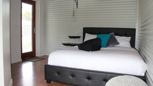 Un dormitorio con una cama grande, un cabecero y una mesita de noche.