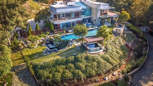 A modern two-story house with a swimming pool, surrounded by lush greenery and hills. - Private Custom Modern 10,000 sq. Ft. Estate -- Nestled on 15 Acres (Temecula)