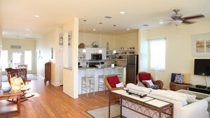 A spacious living area with a kitchen, dining table, and seating arrangements. - Quiet, Big, Bright and Beautiful!  Perfect Beach House for Family and Friends (Port Aransas)