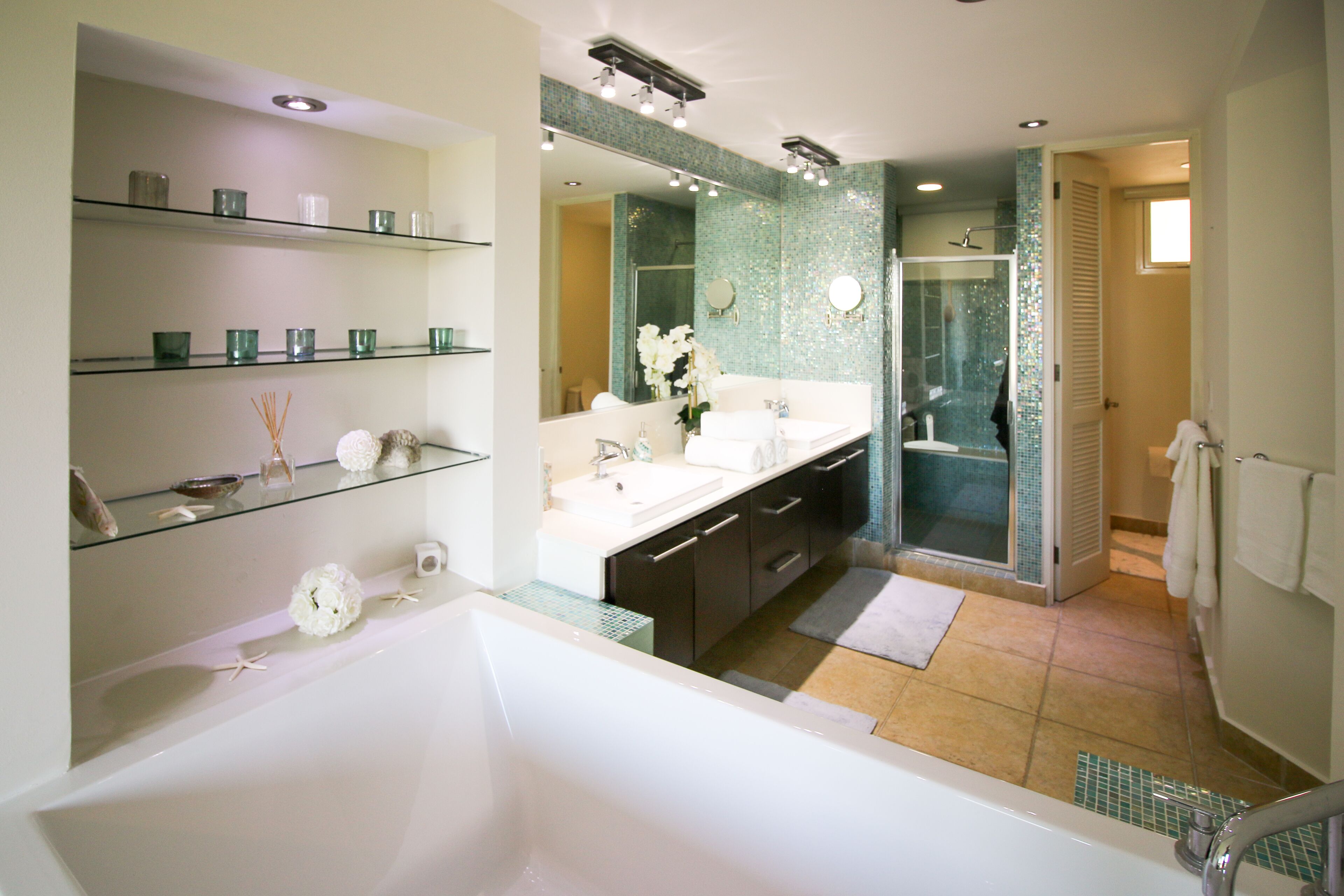 A modern bathroom with a bathtub, a shower, and a vanity with a mirror.