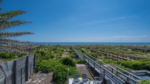 Una passerella di legno che conduce a una spiaggia con vista libera sull'oceano.