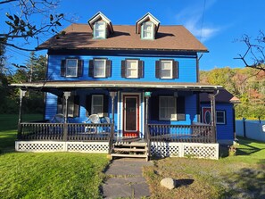 A two-story house with a porch, a front door, and a small window. - Abigail's Country House. 2 minutes To Skiing. Swimming, Hiking very close by. (Hunter)