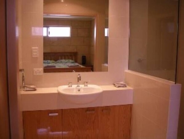 Une salle de bain avec un double lavabo, des meubles en bois et un grand miroir.