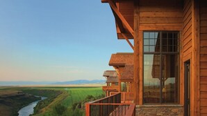 A wooden cabin with a balcony overlooking a river and fields. - Luxury home with Stunning 4 Peak Views (Tetonia)
