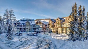 Un hôtel à plusieurs étages, entouré d’un paysage enneigé, qui présente un mélange d’architecture moderne et traditionnelle.
