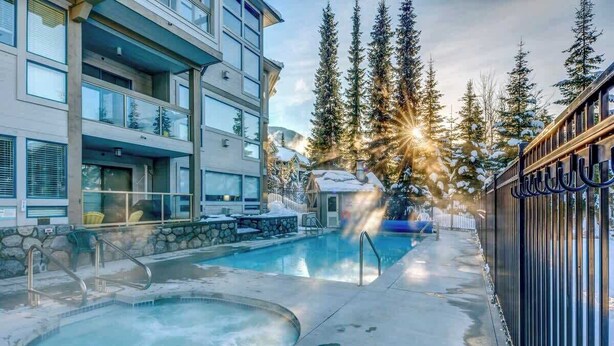Un hôtel doté d'une piscine, d'un espace extérieur aménagé et offrant une vue sur des arbres couverts de neige.