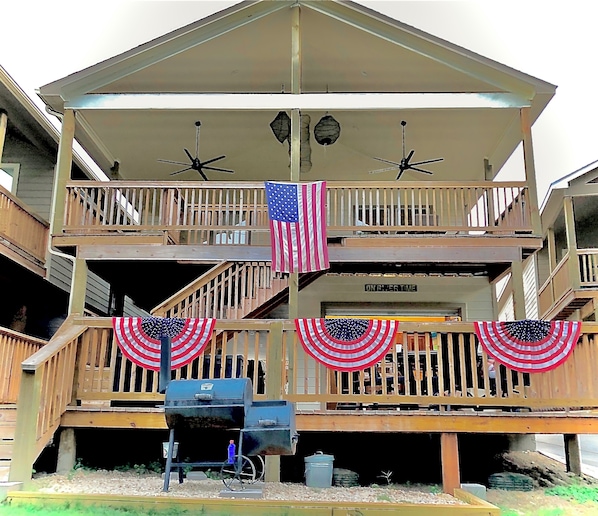 A multi-story building with balconies, a flag, and a sign that reads "ONRYER TIME".