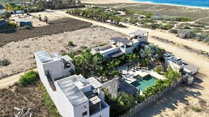 A coastal property with multiple buildings, a swimming pool, and a beach view.