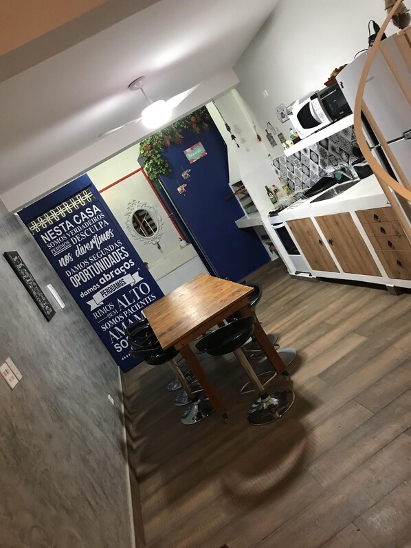 Enjoy meals in this kitchen with a dining table and chairs, microwave, stove, sink, and cabinets.