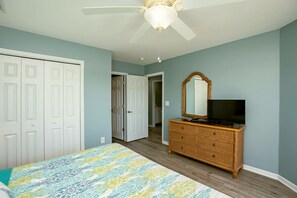 A bedroom with a bed, dresser, television, and a ceiling fan. - Finally Beachin' - Great 4 BR Home - Ocean View & Easy Beach Access!! (Topsail Beach)