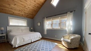 A bedroom with a bed, a chair, a window, and a skylight. - Gorgeous Newer Home on Mt. Desert Island, Minutes to Acadia (Bass Harbor)