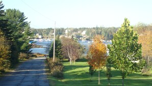 A road leading to a body of water with boats, surrounded by trees and a grassy area. - Gorgeous Newer Home on Mt. Desert Island, Minutes to Acadia (Bass Harbor)