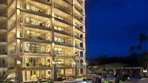 A multi-story hotel with a pool area, including lounge chairs and a water feature. - Manhattan hits Jaco 3br/3.5 ba Panoramic Ocean Views (Jaco)