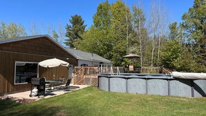 A wooden cabin with a deck, outdoor seating, and a swimming pool. - Beautiful view*Heated Pool*Private*Near Pic Rocks (Christmas)