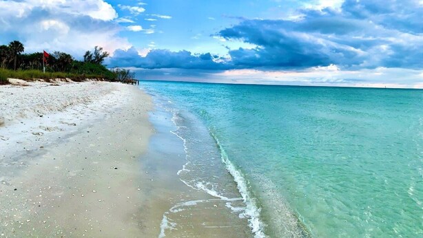 A beach with clear turquoise water and a sandy shore. - 6bdr/4bath tropical paradise with heated pool and lanai, 1 mile from the beach (Naples)