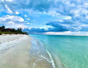 A beach with clear turquoise water and a sandy shore.