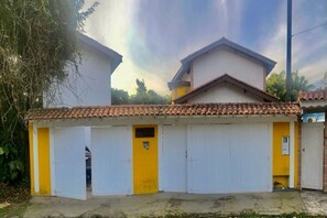 Un bâtiment à deux étages, doté d’un toit en tuiles et de murs jaunes et blancs.