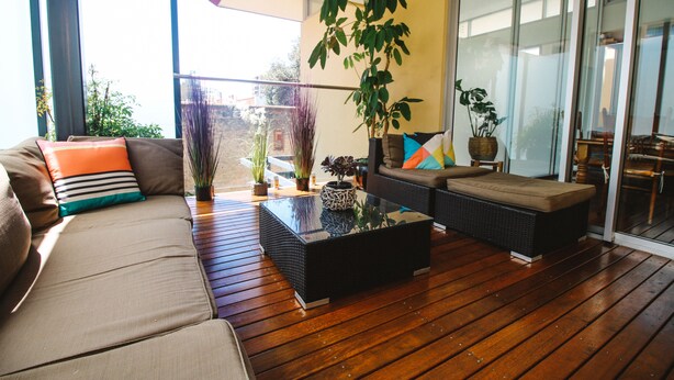 A modern living room with a sofa, a coffee table, and a potted plant. - Hindmarsh House on College | Steps to Glenelg Beach, Cafes & Jetty Road (Glenelg)