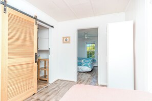 A room with a bed, a wardrobe, and a door leading to another room. - Ruff Life - Classic Island Cottage - 4 BR and Easy Beach Access. Dog Friendly! (Surf City)