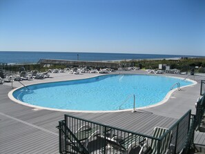 Une piscine avec des chaises longues et vue sur l’océan.