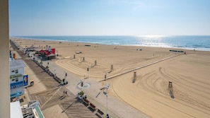 A beach with a boardwalk, beach chairs, and umbrellas. - 🏖️  Oceanfront Boardwalk unit w/ Pool Just Renovated steps to Downtown Events 🏖️ (Ocean City)