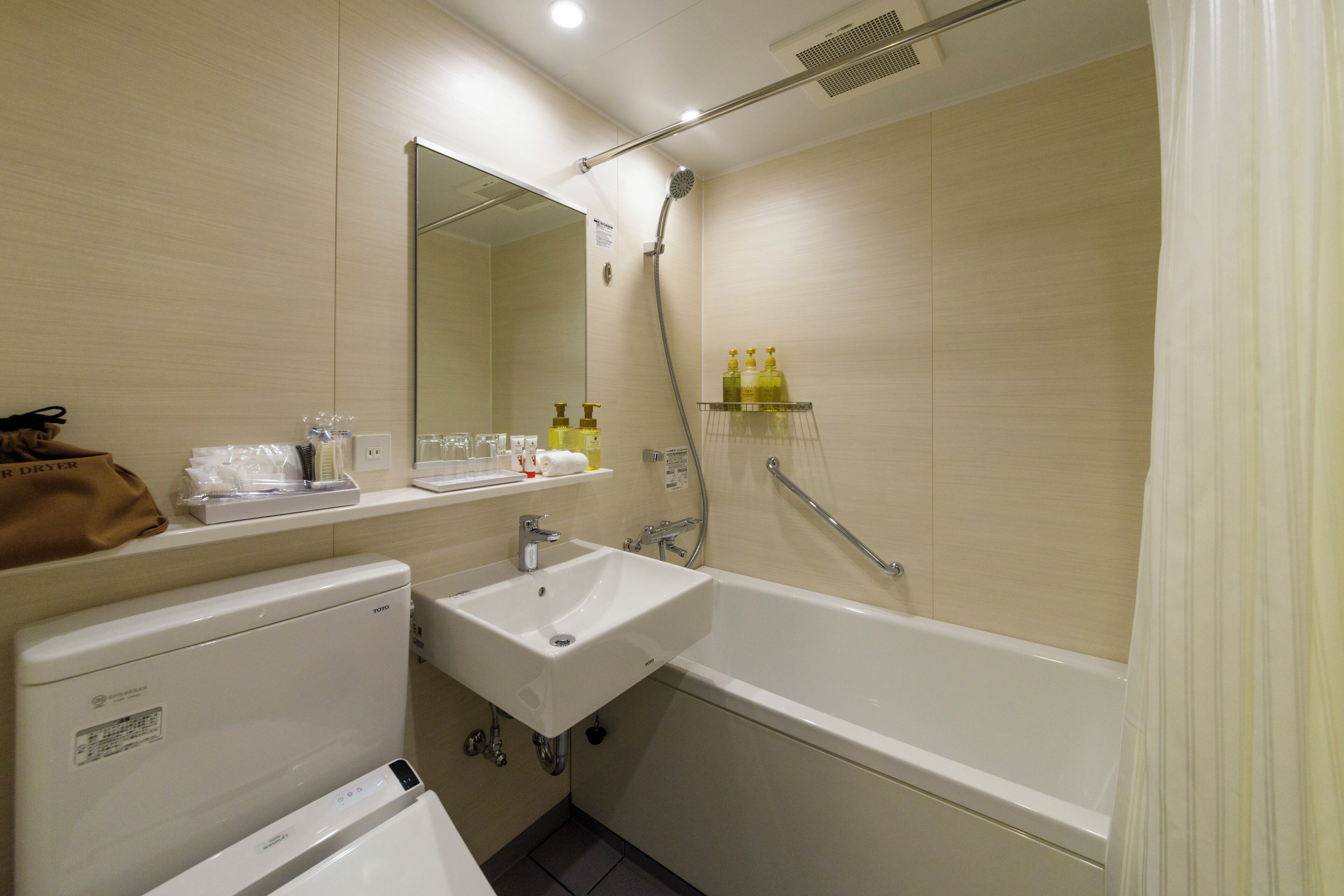 Une salle de bain équipée d’un lavabo, d’un miroir, d’une douche et d’un porte-serviettes.