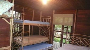 A wooden cabin with bunk beds and a single bed, a window with a view of greenery, and a wooden ceiling. -  Chacara with incredible house on the edge of the river in Antonina, PR -   (Antonina)
