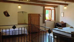 Une pièce avec un plafond en bois, un lit, un bureau et une fenêtre.