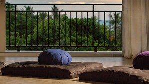 Un balcon avec vue sur les palmiers et l’océan.