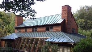 A modern house with a sloped roof, large windows, and a chimney. - Snowberry Hill, 5 bedroom, Private Luxury Ski Home on Killington Mtn, sleeps 12 (Killington)