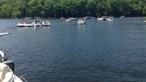 A lake with several boats docked and a forested shoreline in the background. - Lakeside barn wood cottage just remodeled with all the modern Conveniences! (Greentown, PA)