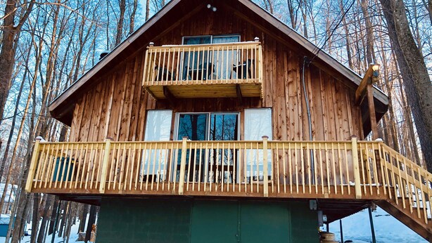 A wooden cabin with a balcony and a green door. - Lakeside barn wood cottage just remodeled with all the modern Conveniences! (Greentown, PA)