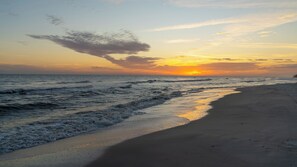 A beach with waves at sunset.