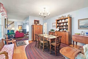 Un comedor con una mesa y sillas de madera, rodeado por un tapete estampado.