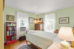 A bedroom with a bed, a red bookshelf, a dresser, and two windows with sheer curtains. - On the Chatham Loop - 1 Min to the Beach! (Chatham)
